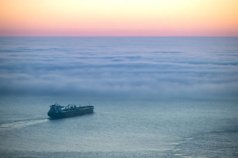 Buque de carga navegando entre la niebla del océano, ruta de una importación desde México a Chile
